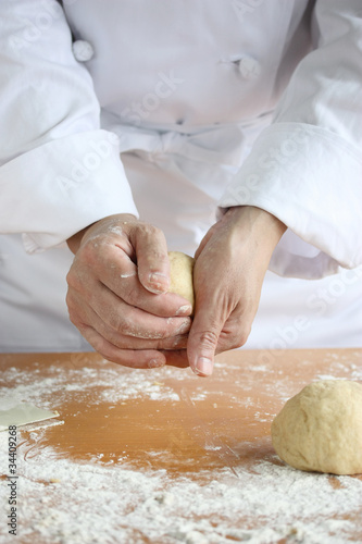 baker making bread , man hands , kneading a dough , cooking coat