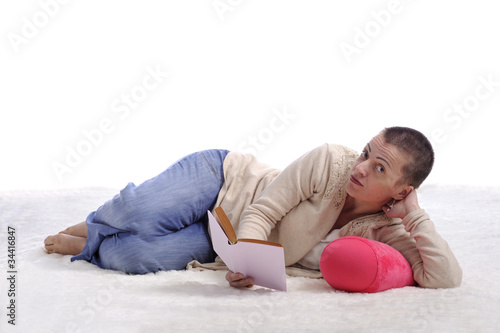woman lying on a carpet reading a book
