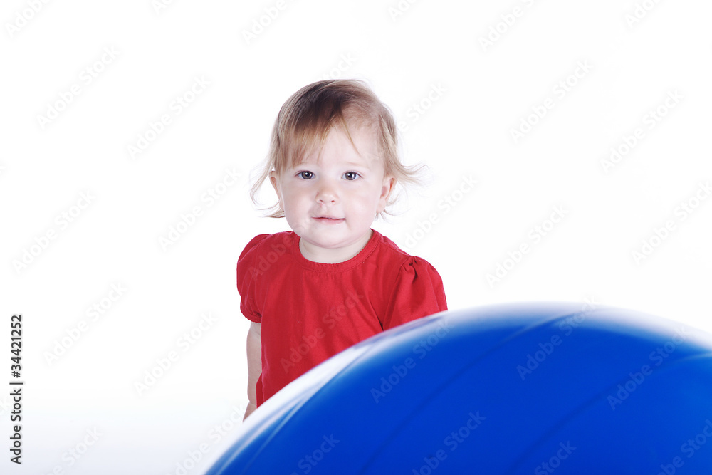 Kleines Mädchen blickt hinter großem Sport Ball hervor Porträt Kleines Mädchen blickt hinter großem Sport Ball hervor Porträt