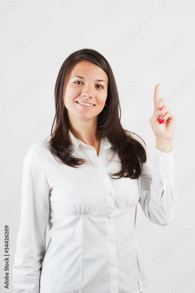 Happy smiling young business woman showing blank area for sign o Happy smiling young business woman showing blank area for sign o