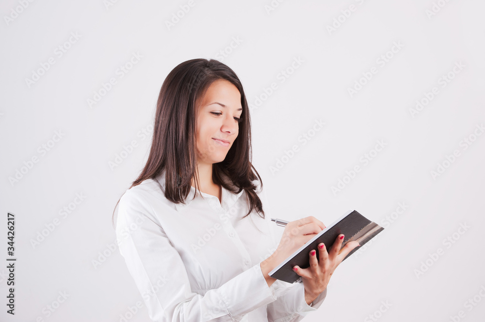 Happy smiling young businesswoman with clipboard writing Happy smiling young businesswoman with clipboard writing