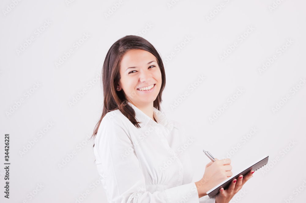 Happy smiling young businesswoman with clipboard writing Happy smiling young businesswoman with clipboard writing