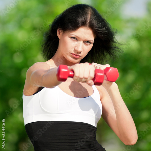 Woman doing exercise with dumbbell
