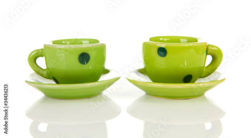 green dotted tableware cups over white background