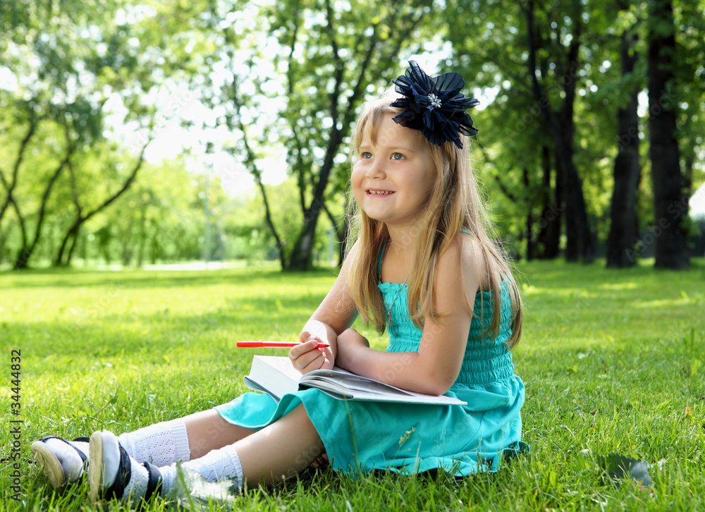 Portrait of little girl reading a book in the park Portrait of little girl reading a book in the park