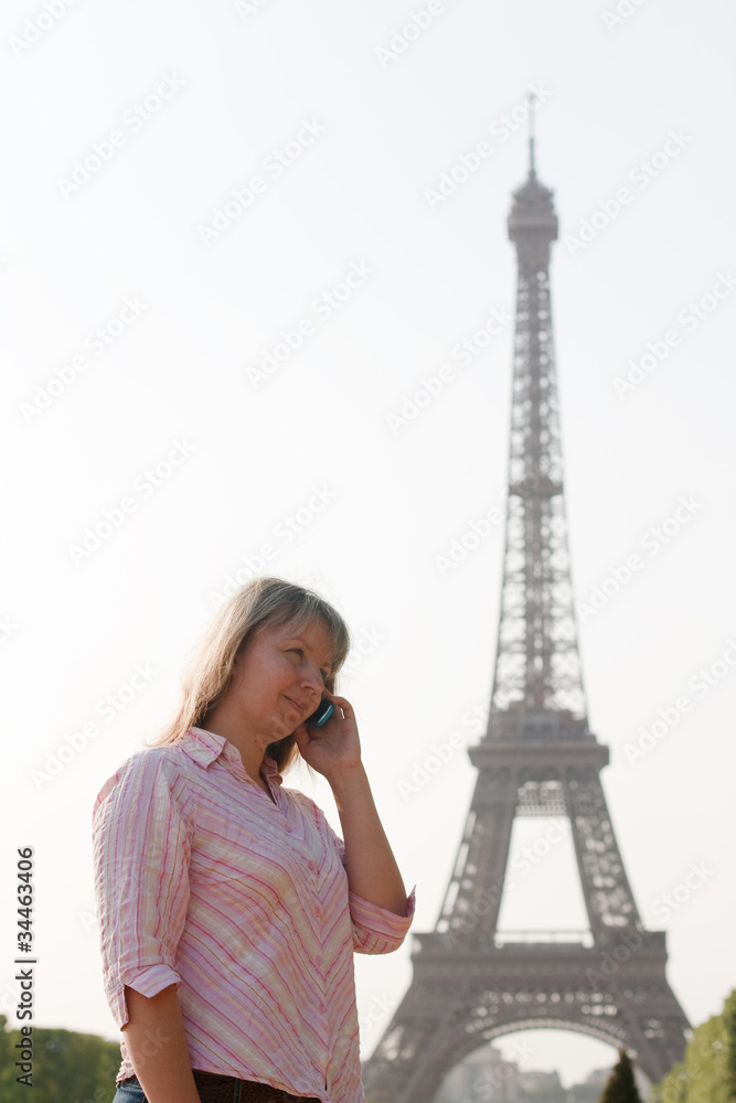 The girl with the phone against the backdrop of the Eiffel Tower