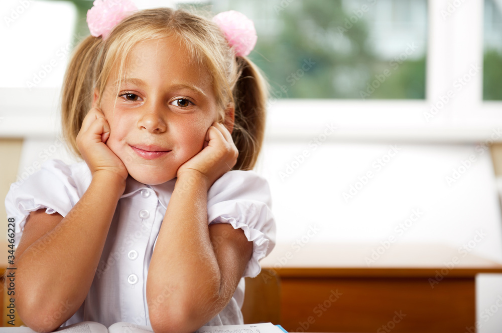 Image of smart child reading interesting book in classroom Image of smart child reading interesting book in classroom