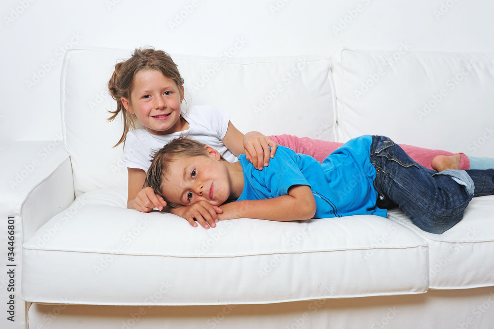 Zwei Kinder liegen auf dem Sofa StockFoto Adobe Stock