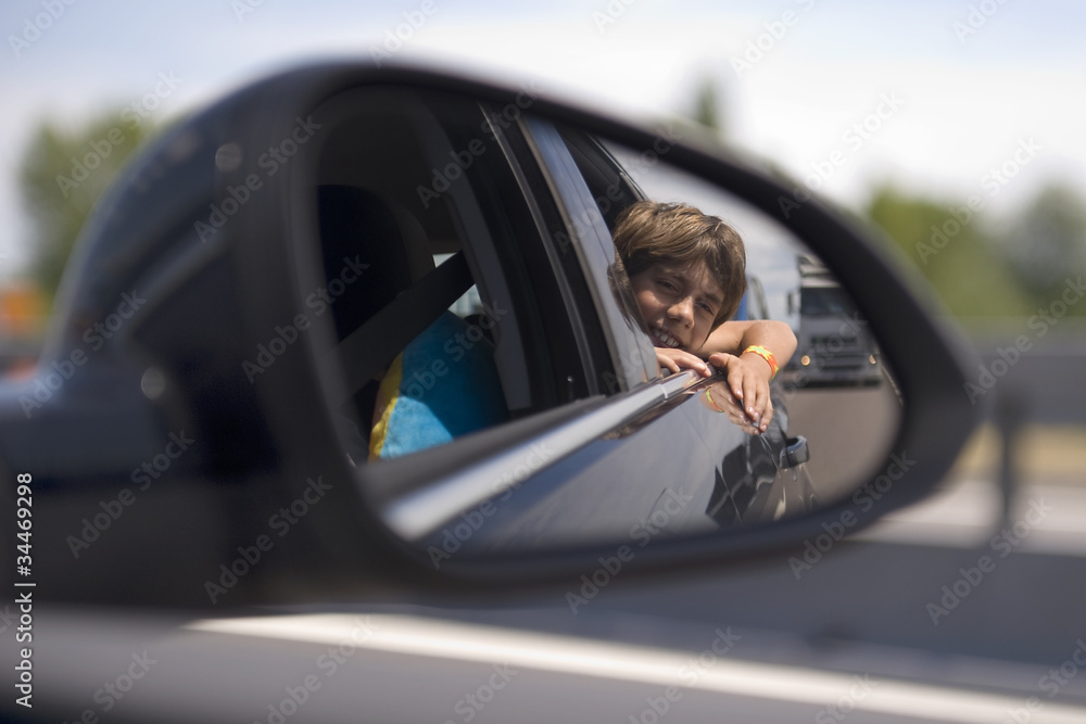 a boy in a car mirror a boy in a car mirror