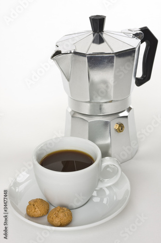 Eine Tasse mit Kaffee und ein Percolator auf einem weißen Hintergrund