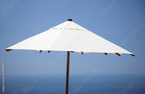 white parasol  blue sea and sky  far away