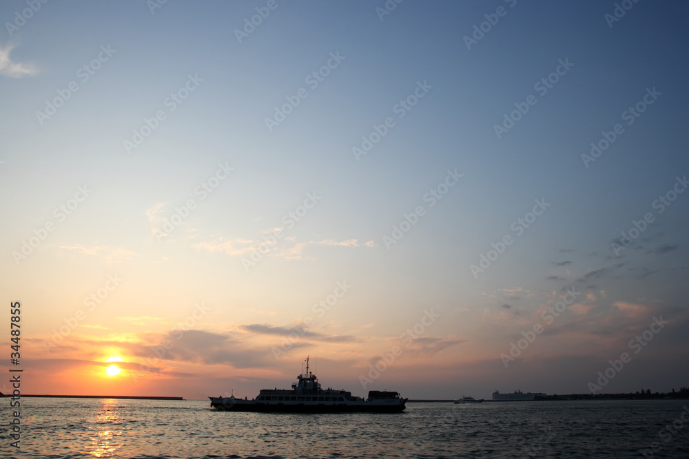 Ship in the background of a sunset at sea Ship in the background of a sunset at sea