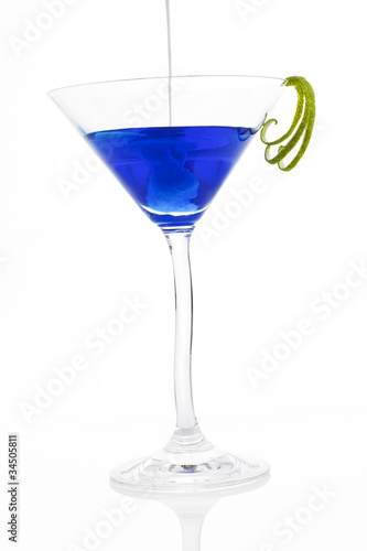 Poring cream into a blue cocktail.
