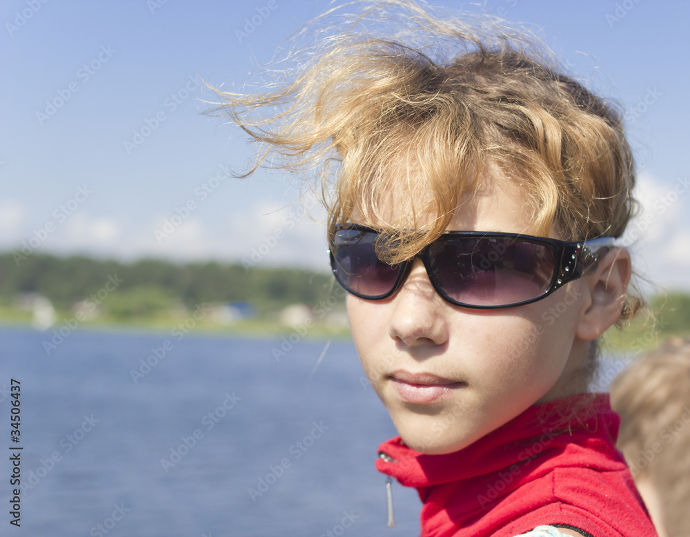 Portrait of young girl in sunglasses looking at the water Portrait of young girl in sunglasses looking at the water