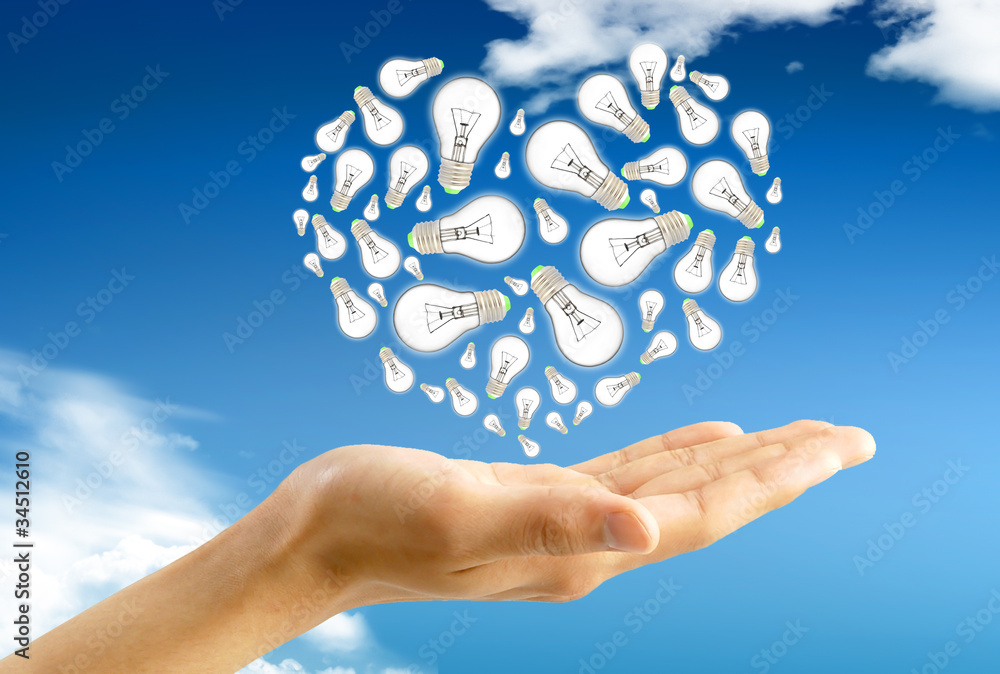 Ecological energy. Hand holds a light bulb against blue sky