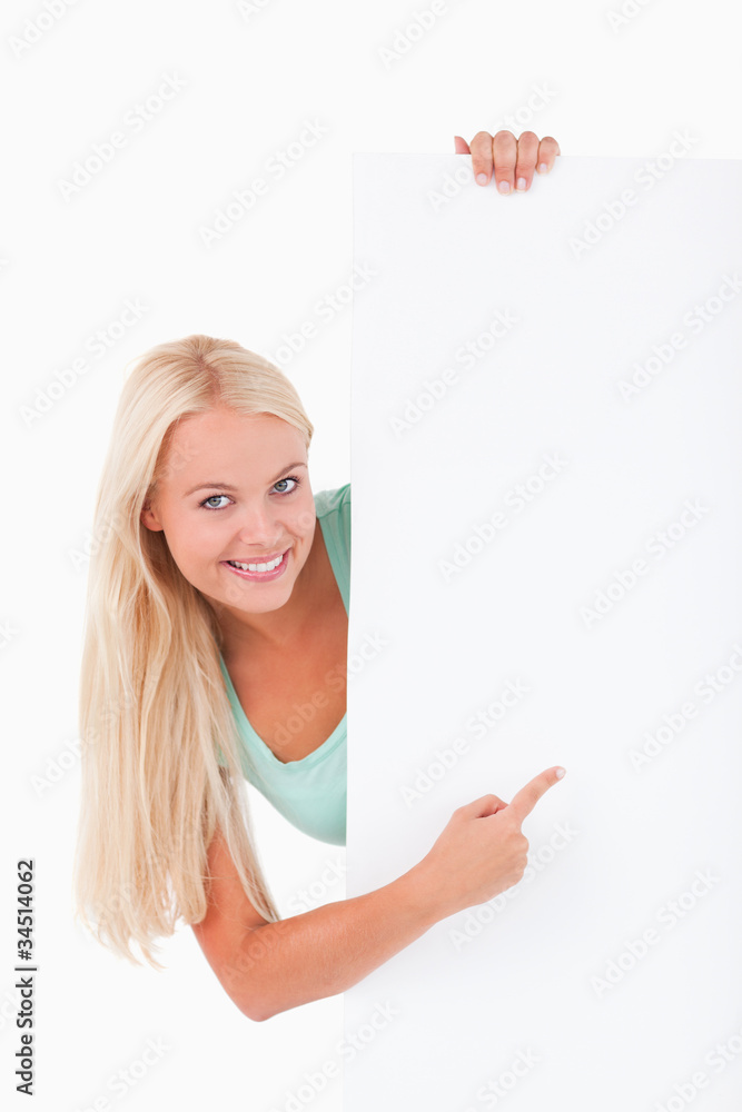 Blond-haired smiling woman pointing at a whiteboard Blond-haired smiling woman pointing at a whiteboard