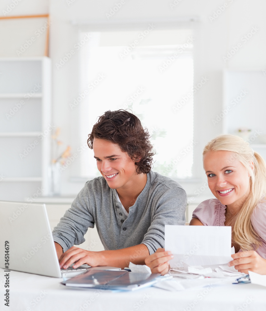 Fototapeta premium Happy couple with bills and laptop