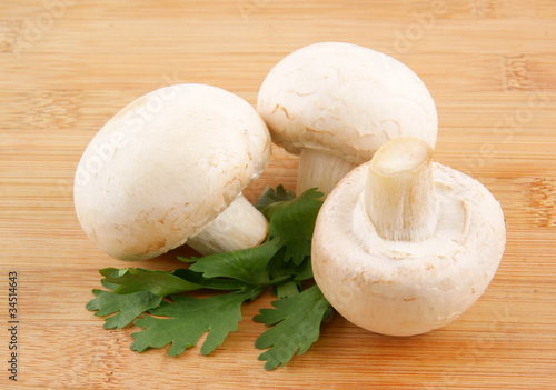Fresh mushrooms and parsley on wooden background