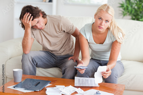 Worried couple calculating their expenses