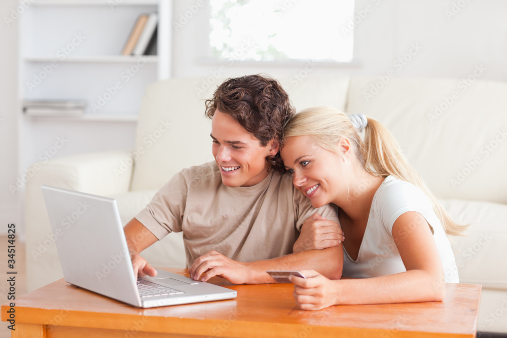 Cute couple with a laptop and a credit card Cute couple with a laptop and a credit card
