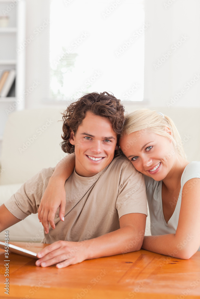 Close up of a Hugging cute couple with a tablet