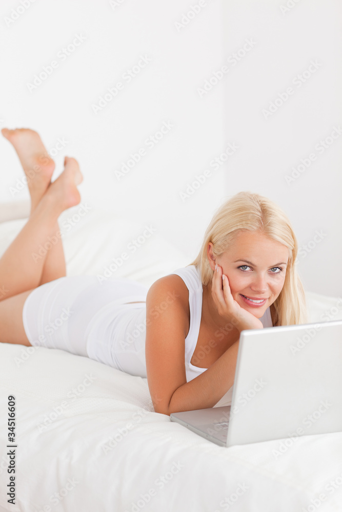 Portrait of a woman using a laptop on her bed Portrait of a woman using a laptop on her bed