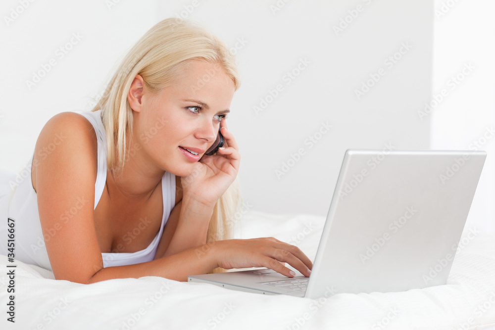 Blonde woman on the phone using a notebook Blonde woman on the phone using a notebook