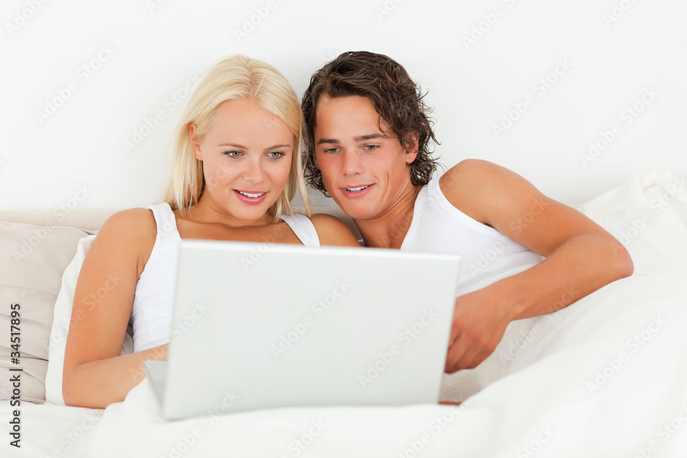 Young couple watching a movie with a laptop Young couple watching a movie with a laptop