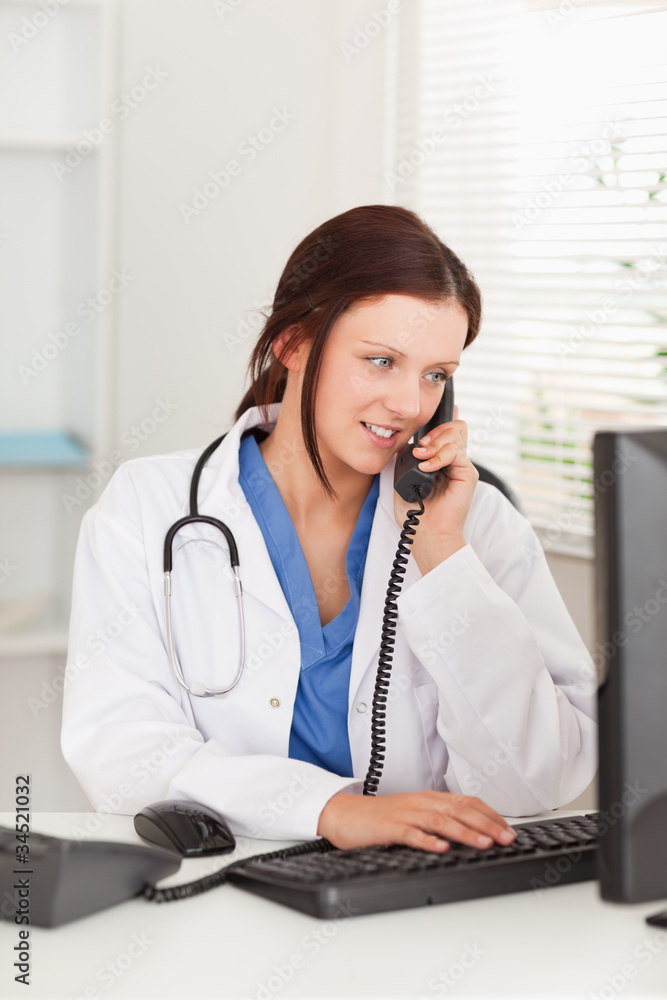 Female doctor telephoning by pc Female doctor telephoning by pc