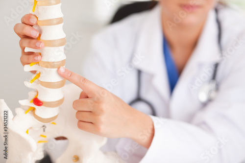 Schilderij op canvas Doctor pointing at bone in spine