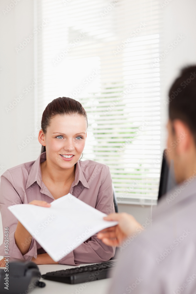 A businesswoman presents a contract to a customer A businesswoman presents a contract to a customer