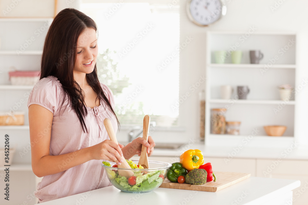 Cute woman mixing a salad