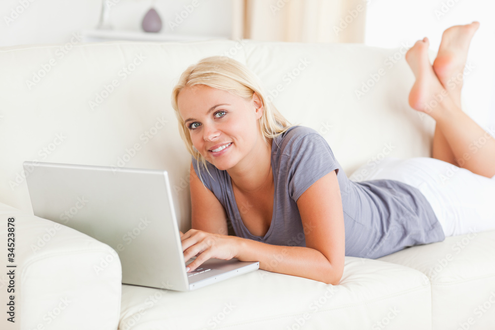 Lying blonde woman using a laptop Lying blonde woman using a laptop