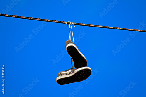 tennis shoes hanging from a power line