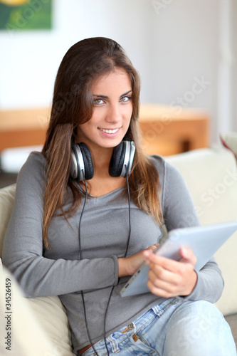 Beautiful woman sitting in sofa with touchpad