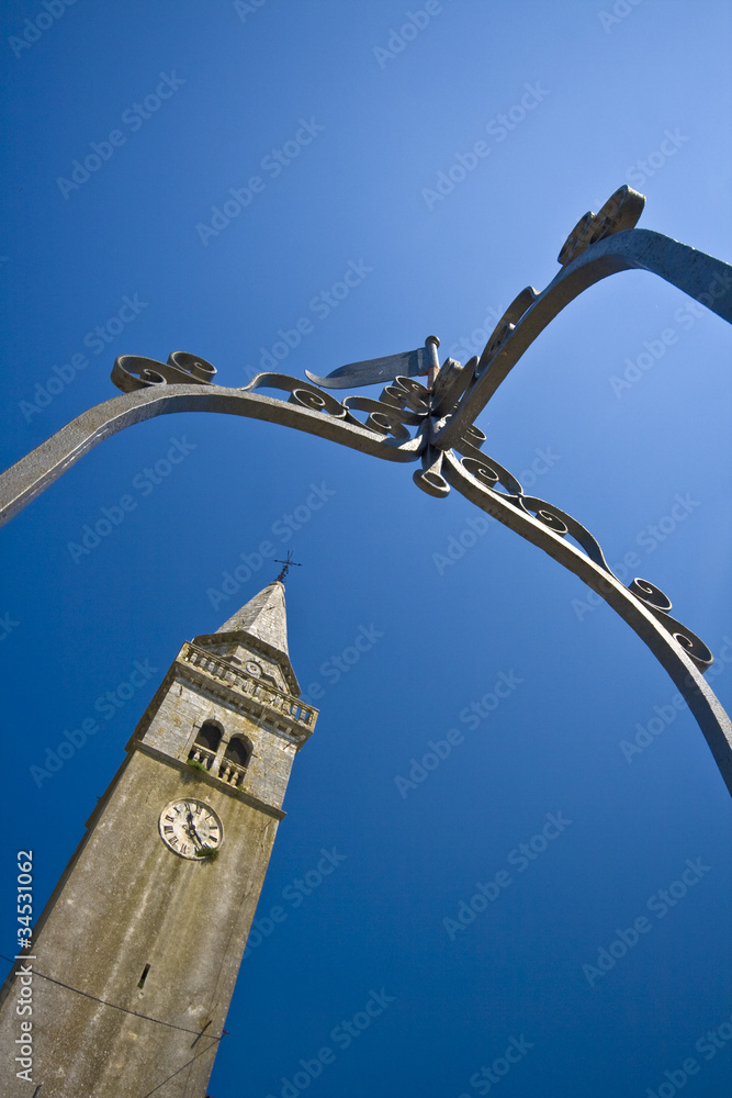 Obraz premium Church and the clock tower from the well in Zminj
