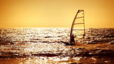 Windsurfer silhouette over sea sunset
