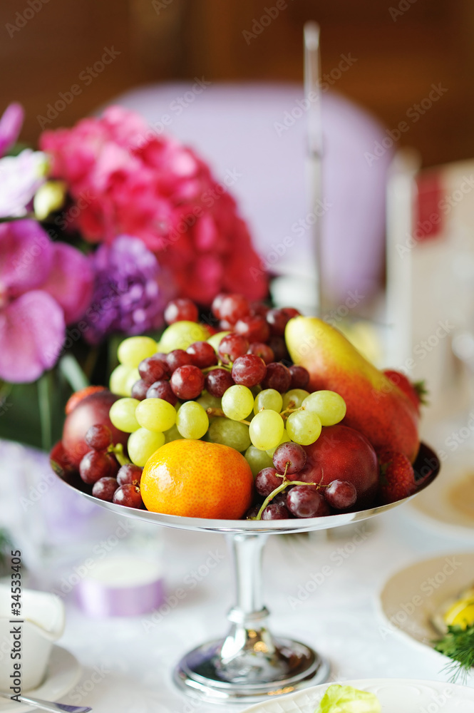 Plate full of fresh fruits on a festive table Plate full of fresh fruits on a festive table