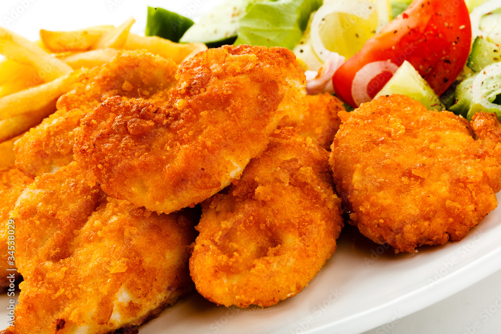 Fried chicken nuggets, French fries and vegetables Fried chicken nuggets, French fries and vegetables