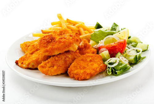 Fried chicken nuggets, French fries and vegetables