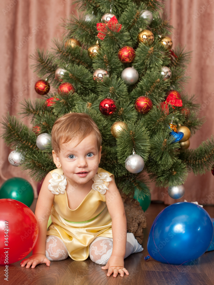 Vibrant toddler at the christmas tree Vibrant toddler at the christmas tree