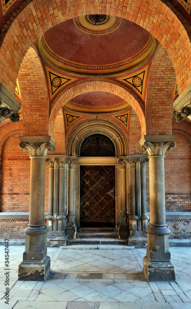 Old door among columns - obrazy, fototapety, plakaty 
