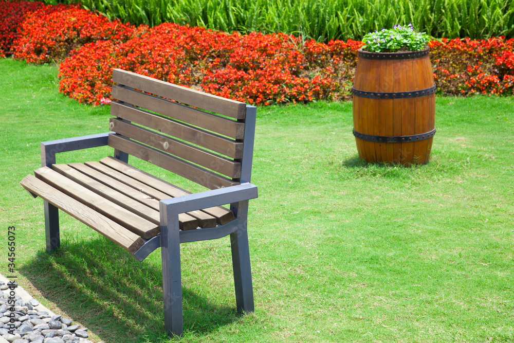 Beautiful summer garden with bench and big decorative wooden flo Beautiful summer garden with bench and big decorative wooden flo