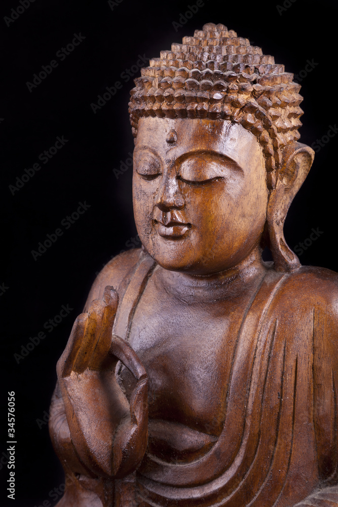 Wooden Buddha on black background