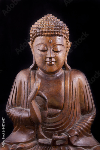 Wooden Buddha on black background