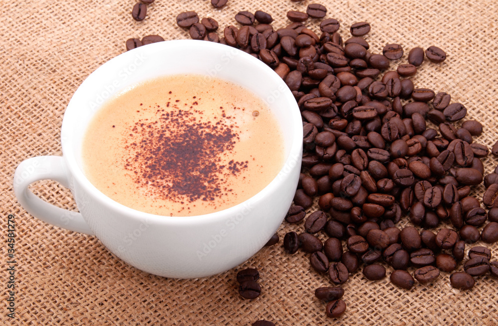 Fototapeta premium Coffee beans with cup on canvas