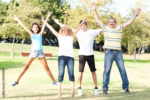 Family jumping with wide-spread raised arms