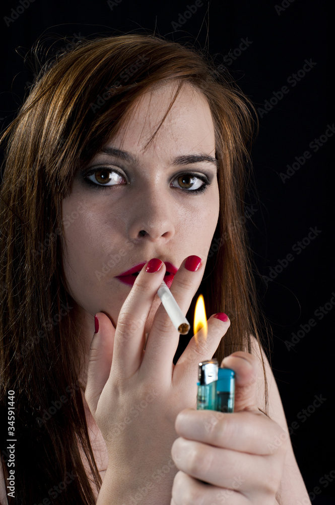Girl lighting a cigarette low key lighting for effect Stock Photo