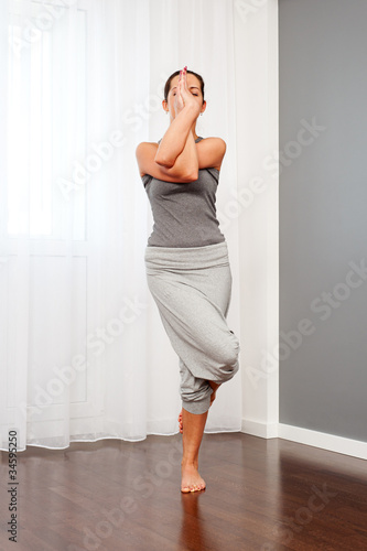female doing yogatic exericise at home photo