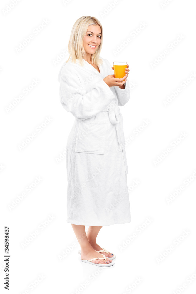 Young woman in bathrobe drinking orange juice for breakfast Young woman in bathrobe drinking orange juice for breakfast